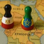 Two game pieces placed on a map of Africa, one in the colors of the Egyptian flag, the other in the colors of the Ethiopian flag