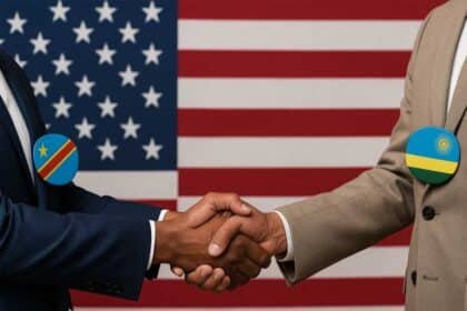 Two political leaders—one representing the Democratic Republic of Congo and the other Rwanda—shake hands in front of a large American flag.